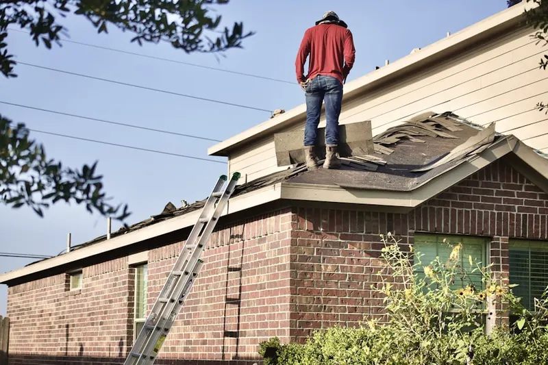 Professional roofer working on a residential roof in Highland Avenue